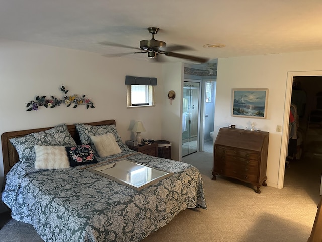 carpeted bedroom with ceiling fan and connected bathroom