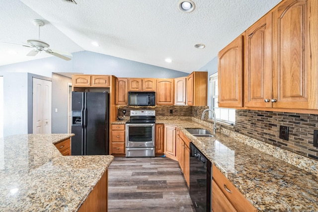 kitchen with sink, light stone counters, vaulted ceiling, dark hardwood / wood-style flooring, and black appliances