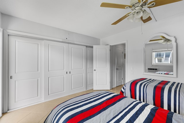 bedroom featuring light tile patterned floors, ceiling fan, and a closet