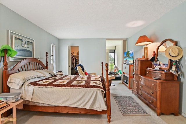 carpeted bedroom featuring a closet, a spacious closet, and a textured ceiling