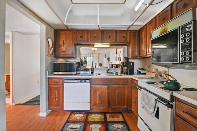 kitchen featuring sink, white appliances, and light hardwood / wood-style floors