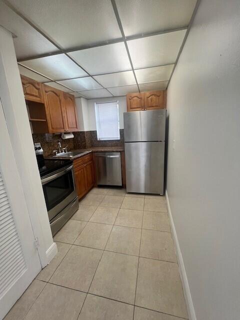 3200 Coral Springs Dr Unit 103, Coral Springs, FL 33065 - kitchen with sink, decorative backsplash, light tile patterned floors, stainless steel appliances, and a drop ceiling