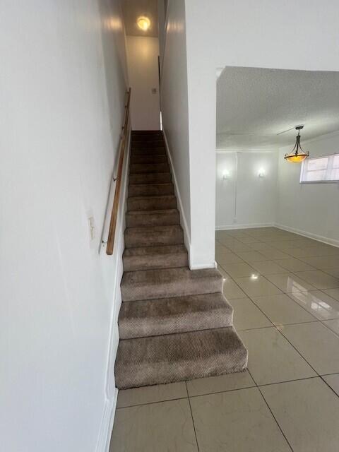 3200 Coral Springs Dr Unit 103, Coral Springs, FL 33065 - stairs featuring ornamental molding and tile patterned floors