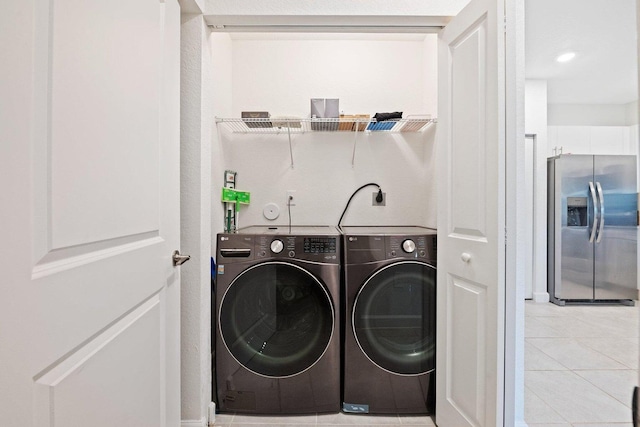 laundry area featuring washing machine and dryer and light tile patterned floors