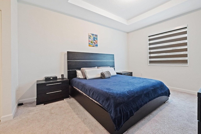 carpeted bedroom featuring a tray ceiling