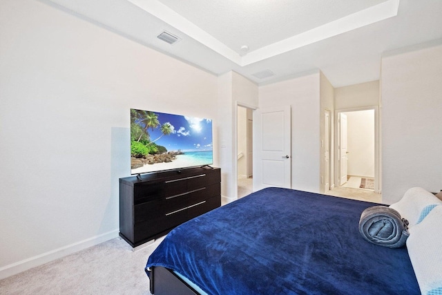 bedroom featuring a raised ceiling and light carpet