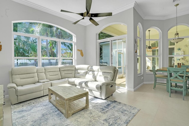 living room featuring light tile patterned floors, baseboards, a ceiling fan, and crown molding