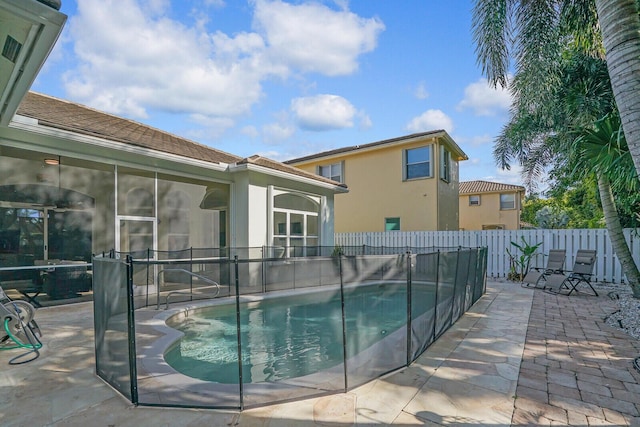 view of swimming pool with a patio area and a sunroom