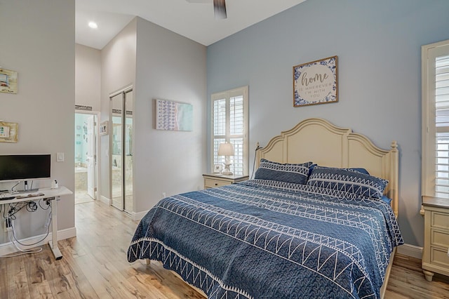 bedroom with ceiling fan, connected bathroom, a closet, and light wood-type flooring