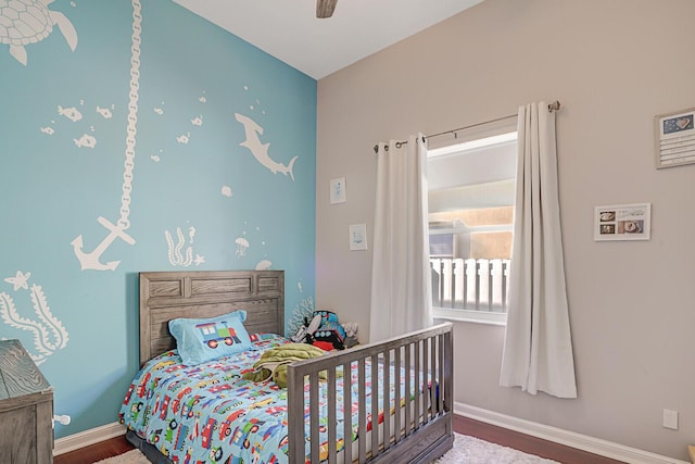 bedroom with ceiling fan, baseboards, and wood finished floors