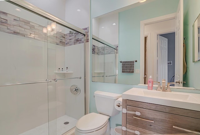 bathroom featuring vanity, an enclosed shower, and toilet