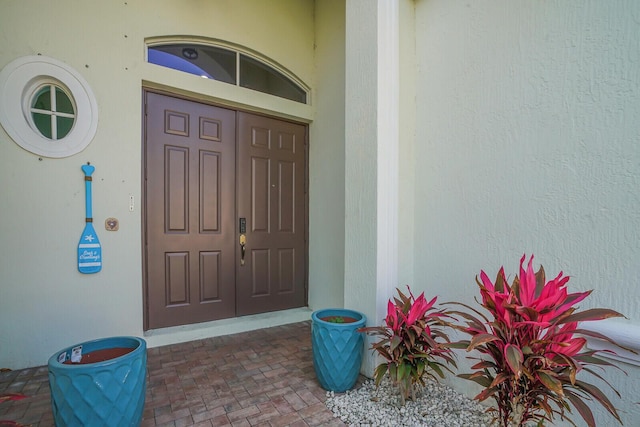 view of exterior entry with stucco siding