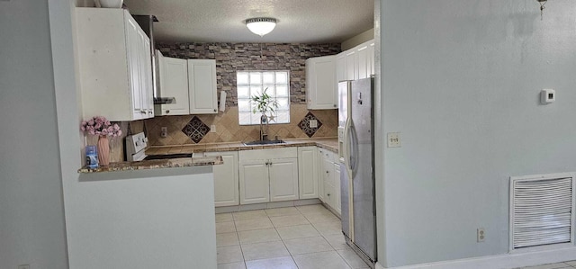 kitchen featuring sink, white cabinetry, stove, backsplash, and stainless steel fridge with ice dispenser