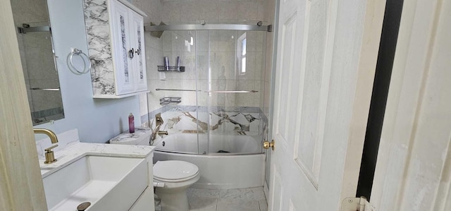 full bathroom featuring toilet, vanity, and shower / bath combination with glass door