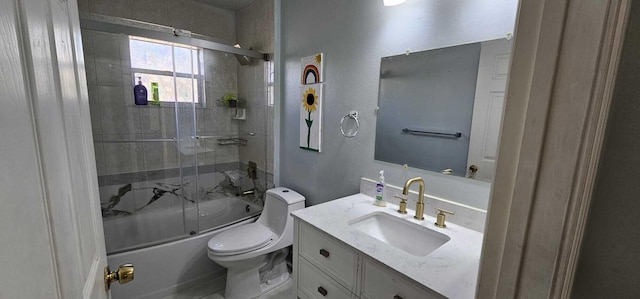 full bathroom featuring vanity, shower / bath combination with glass door, and toilet