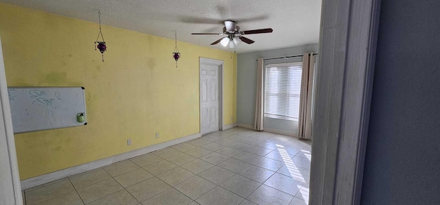 unfurnished room featuring light tile patterned flooring, ceiling fan, and a textured ceiling