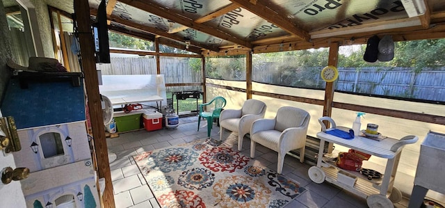 sunroom featuring lofted ceiling and a healthy amount of sunlight