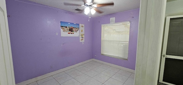 tiled spare room with ceiling fan