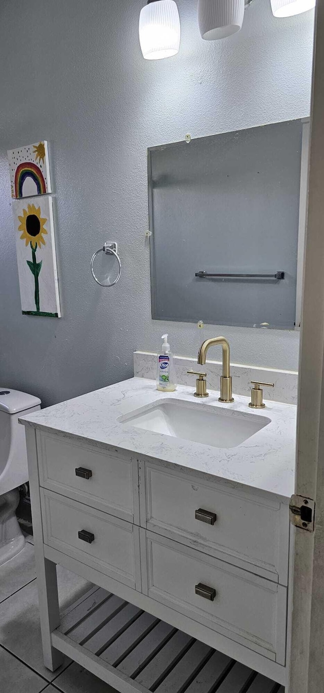 bathroom featuring vanity, tile patterned floors, and toilet