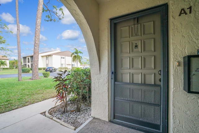 entrance to property featuring a yard