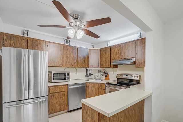 kitchen featuring sink, light tile patterned floors, ceiling fan, kitchen peninsula, and stainless steel appliances