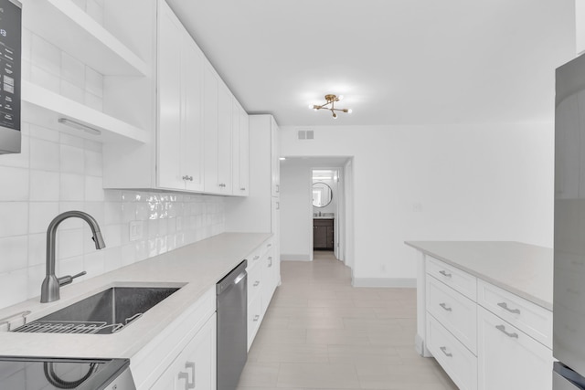 kitchen featuring sink, white cabinetry, range, stainless steel dishwasher, and decorative backsplash