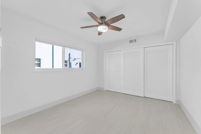 unfurnished bedroom with ceiling fan and a closet