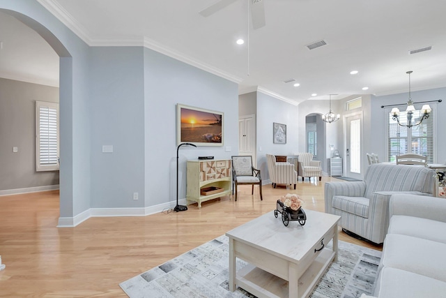 6718 Jog Palm Dr, Boynton Beach, FL 33437 - living room featuring arched walkways, light wood-style flooring, a chandelier, crown molding, and baseboards