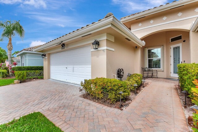 6718 Jog Palm Dr, Boynton Beach, FL 33437 - view of front facade featuring stucco siding, decorative driveway, and an attached garage
