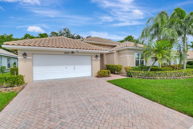 6718 Jog Palm Dr, Boynton Beach, FL 33437 - mediterranean / spanish-style home with decorative driveway, stucco siding, an attached garage, a front lawn, and a tile roof