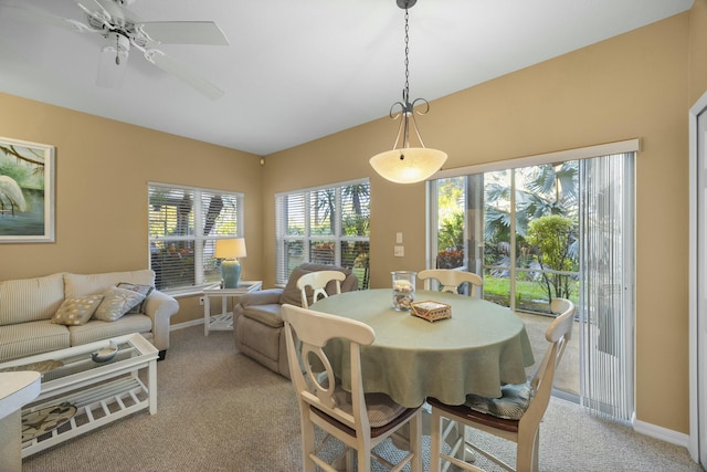 carpeted dining area with ceiling fan