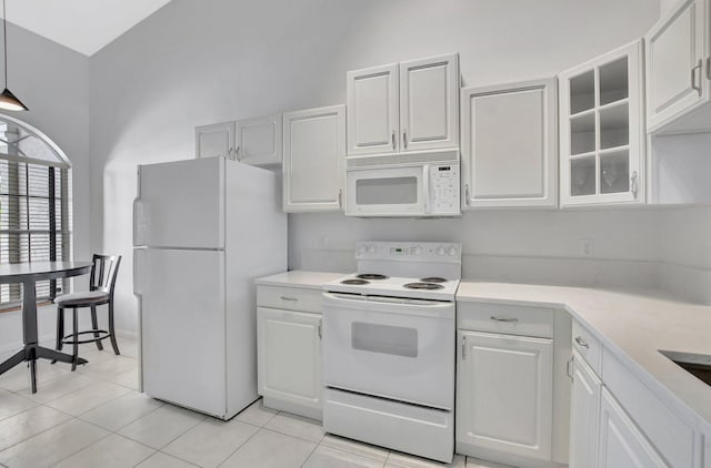 kitchen featuring white cabinetry, light tile patterned floors, and white appliances