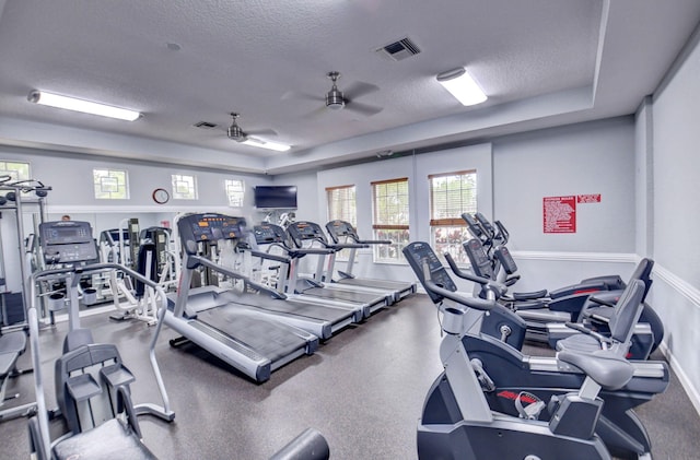 gym featuring ceiling fan and a textured ceiling