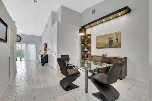 tiled dining room featuring high vaulted ceiling and built in shelves