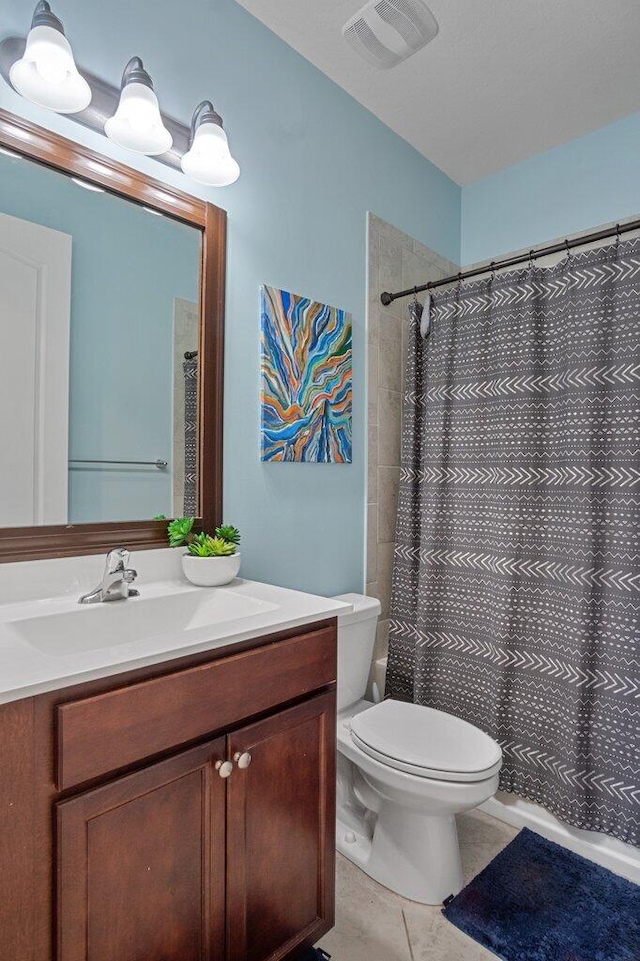 bathroom featuring walk in shower, vanity, toilet, and tile patterned flooring