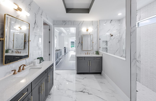 bathroom with tiled shower and vanity