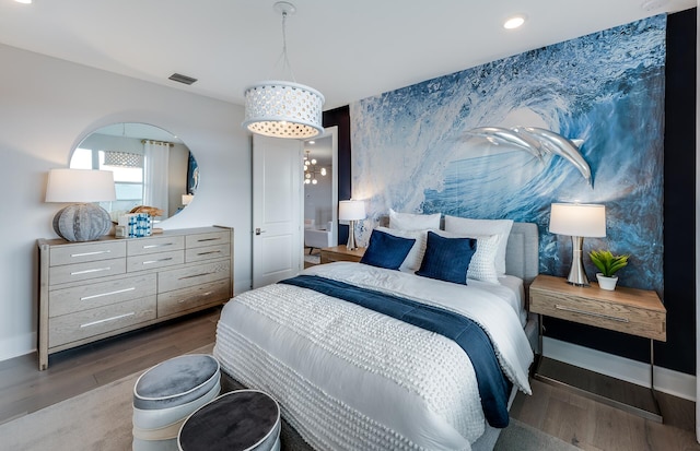 bedroom with a notable chandelier and hardwood / wood-style floors