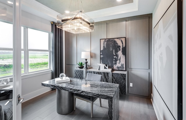 dining room with a tray ceiling, a chandelier, and dark hardwood / wood-style flooring