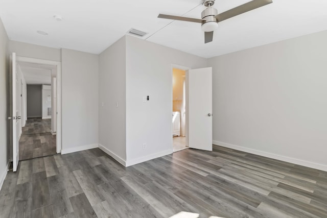 spare room with dark hardwood / wood-style flooring and ceiling fan