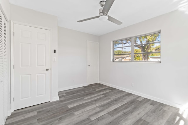 unfurnished bedroom featuring hardwood / wood-style flooring, ceiling fan, and a closet