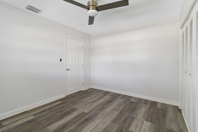 unfurnished room with dark hardwood / wood-style floors and ceiling fan