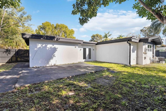 back of property with a yard, a patio area, and french doors