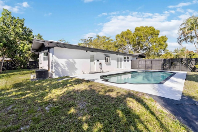 rear view of property featuring a fenced in pool, a patio, a yard, and cooling unit