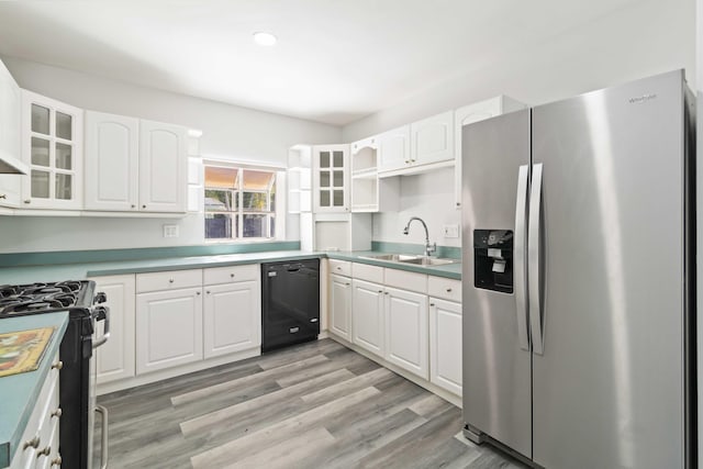 kitchen featuring white cabinetry, appliances with stainless steel finishes, sink, and light wood-type flooring