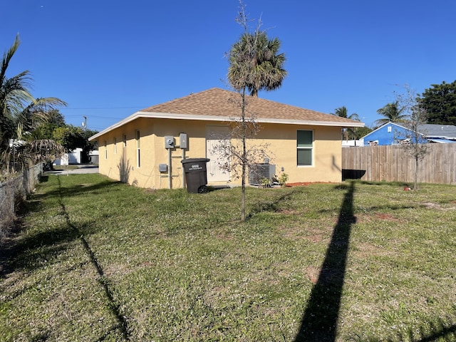 view of side of property featuring a lawn and central air condition unit