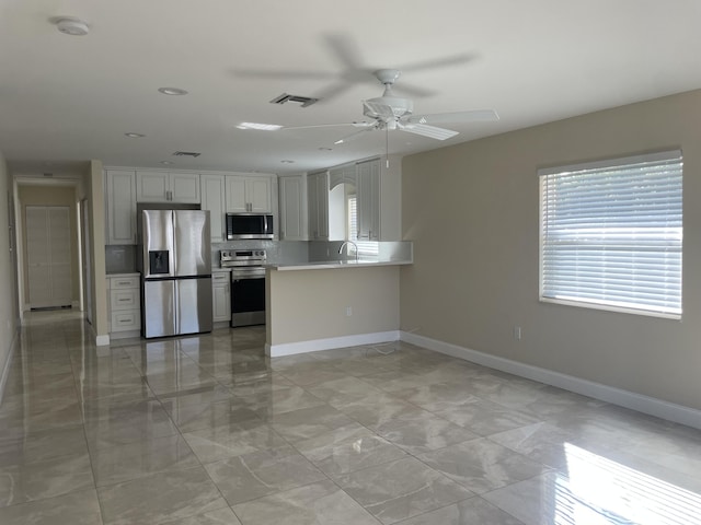 kitchen featuring white cabinetry, stainless steel appliances, kitchen peninsula, and a wealth of natural light