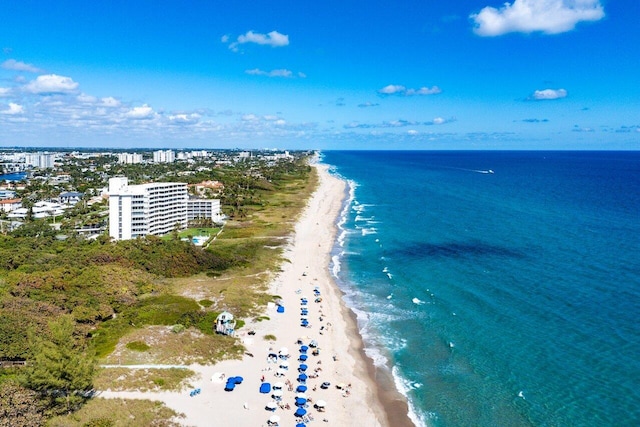 birds eye view of property with a water view and a beach view