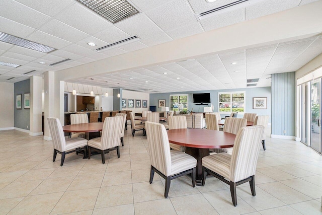 tiled dining room featuring a drop ceiling