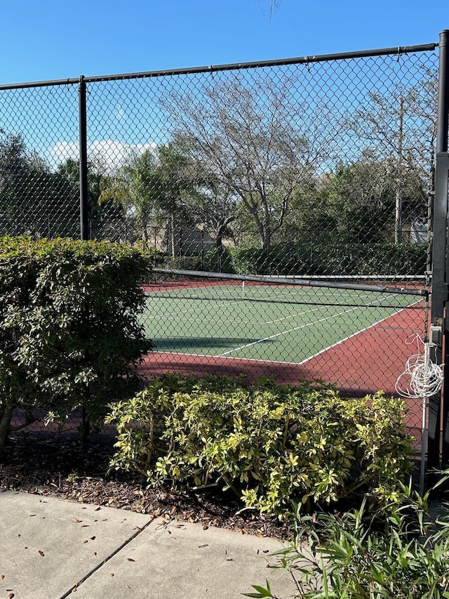 view of tennis court featuring fence