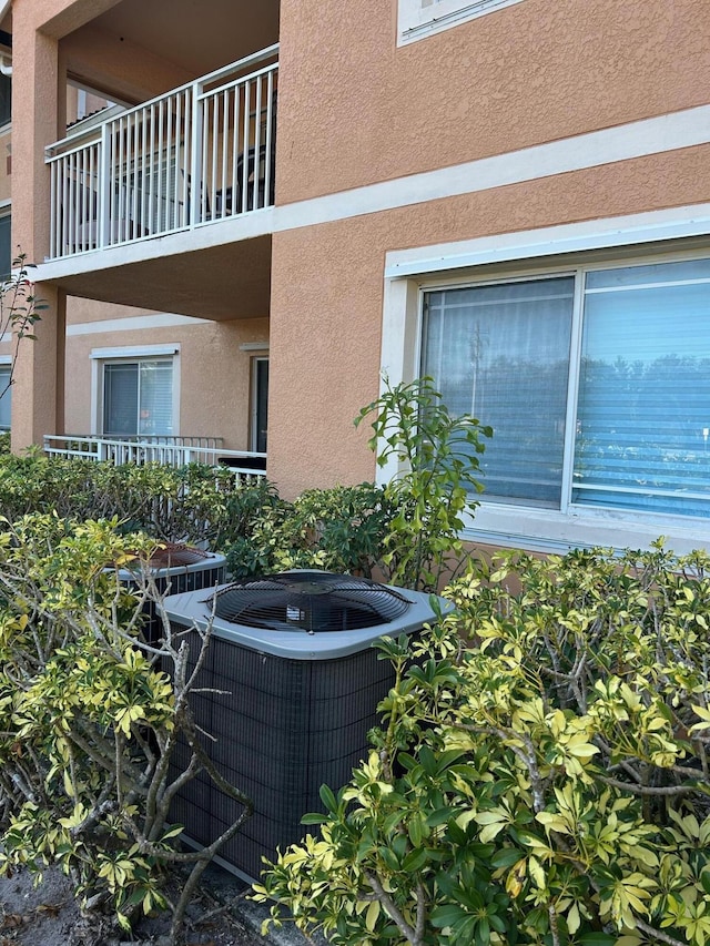 exterior space with stucco siding and central AC unit